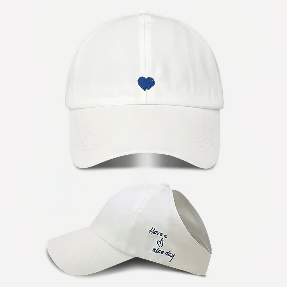 White adjustable cotton baseball cap with small blue heart design on front and 'Have a nice day' message on side, stylish and trendy.